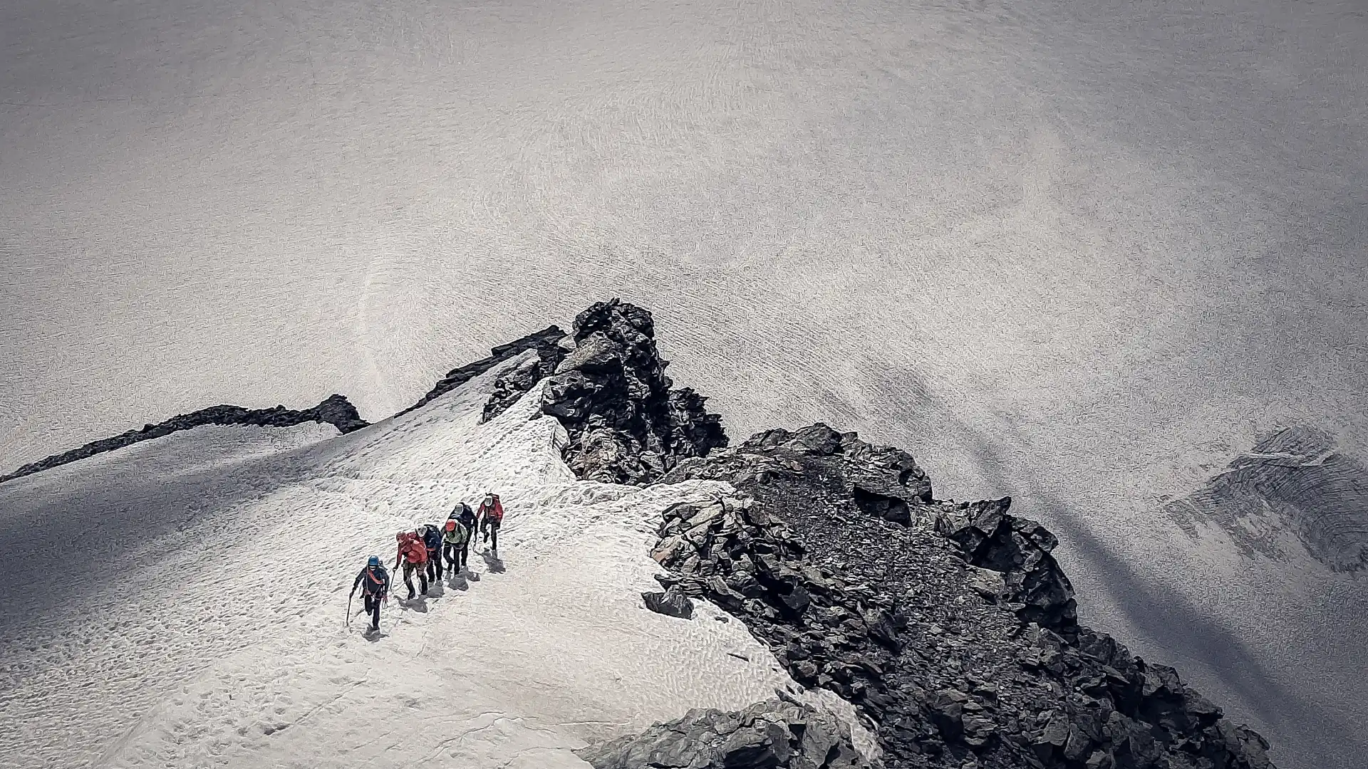 Cordée d'alpinistes montant ensemble une arête enneigée